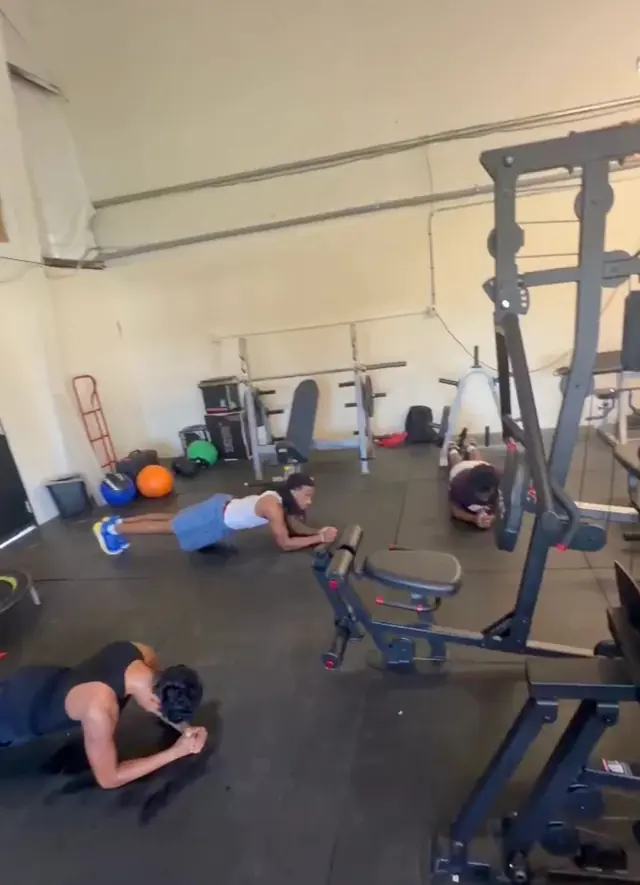 Three athletes holding planks during a small group session